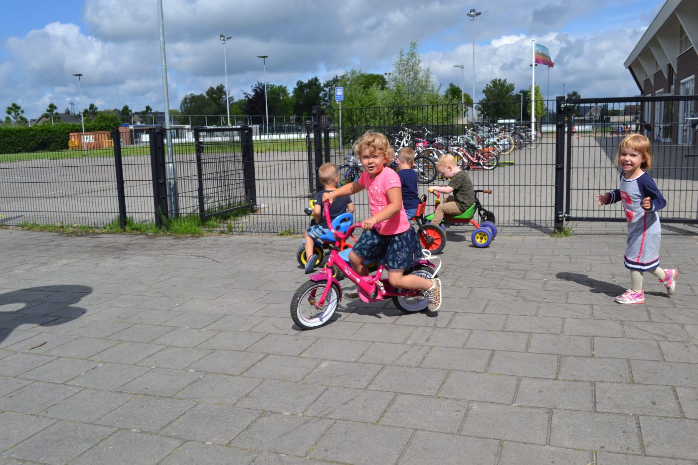 Kinderen fietsen en rennen lachend over het schoolplein